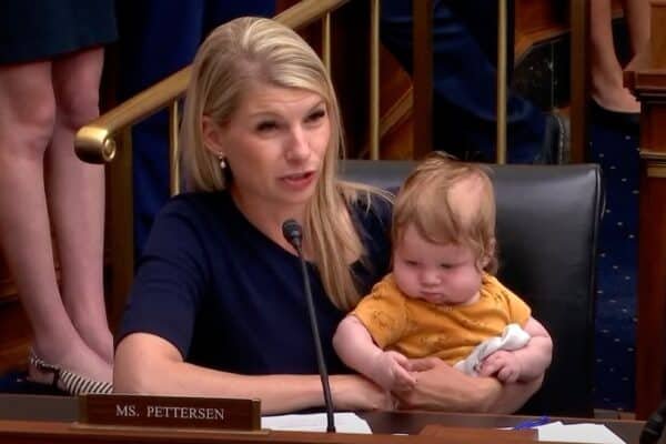 The representative Pettersen brings Baby Son while asking Fed's president at the audience