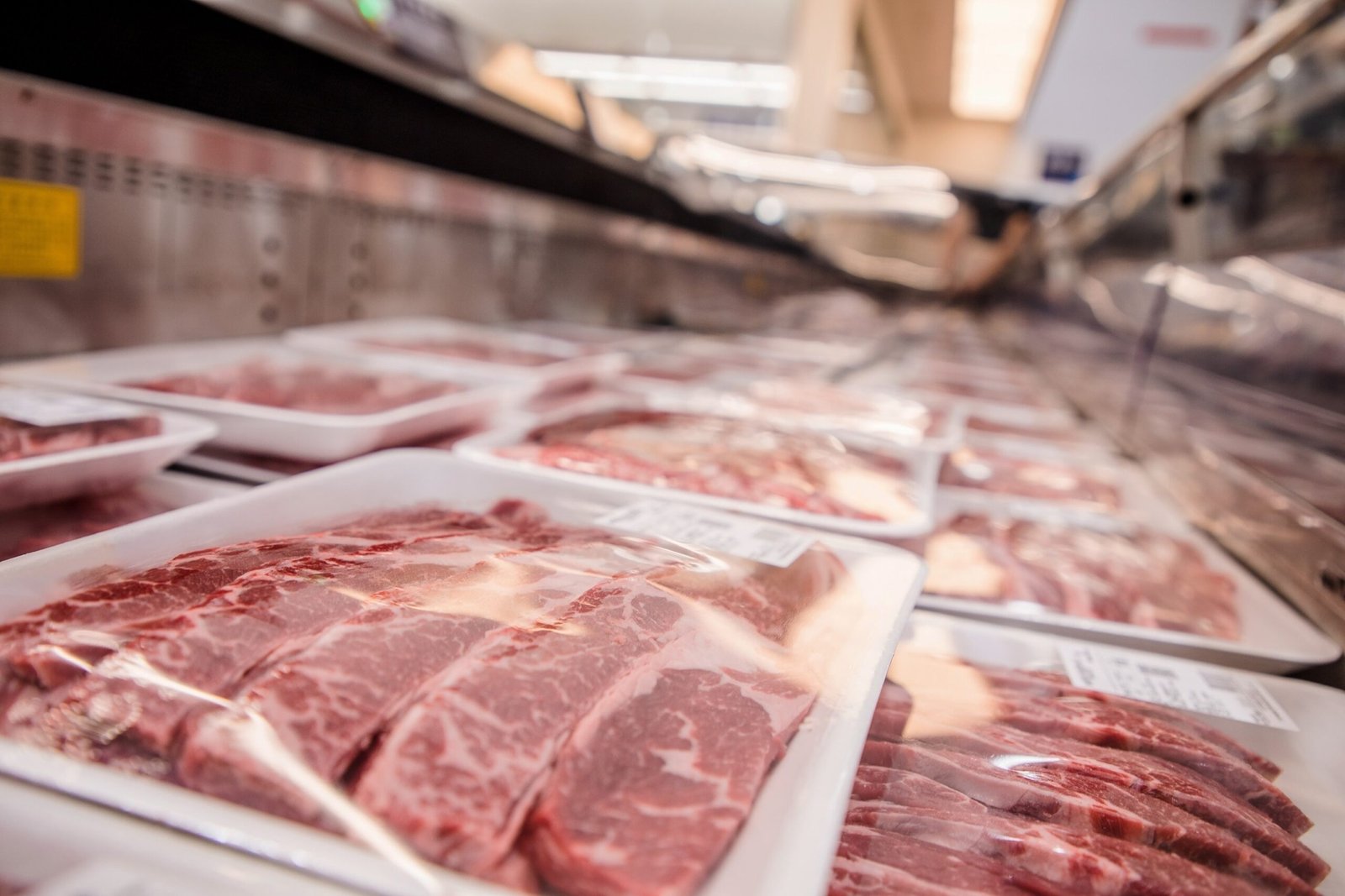 PHOTO: Low angle view of a variety of meat packed on trays in the supermarket freezer