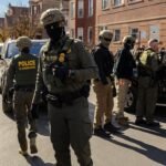 PHOTO: Federal agents confront community members during immigration raids